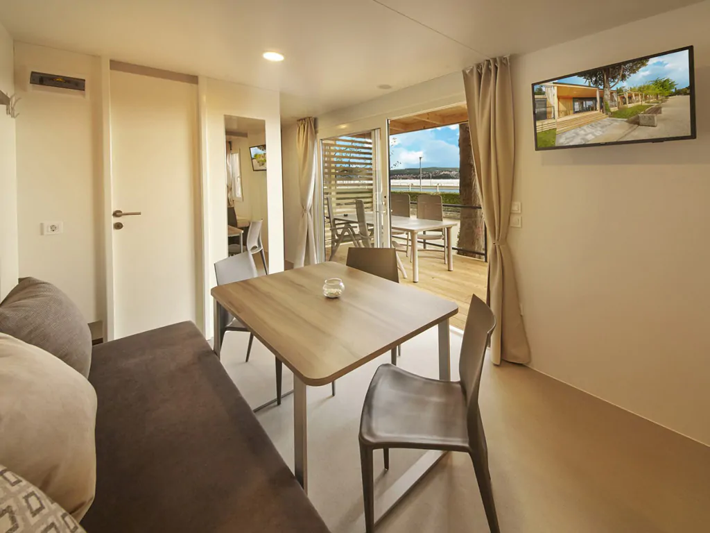 campsite-adria-ankaran-mobile-home-premium-interior-living-room-tv-view-on-terrace