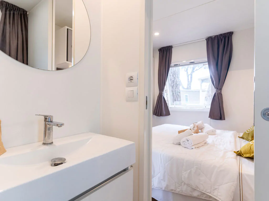 orbetello-family-collection-lodge-superior-family-interior-bathroom-sink-and-bedroom-view